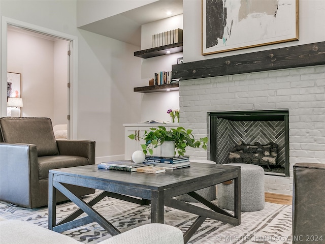 living room featuring light wood-type flooring and a brick fireplace