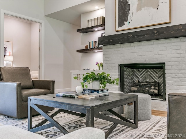 living room with a brick fireplace and light hardwood / wood-style flooring