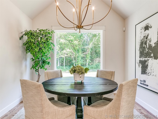 dining room with a wealth of natural light, hardwood / wood-style flooring, and lofted ceiling