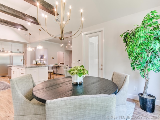 dining area featuring sink, light hardwood / wood-style floors, and vaulted ceiling with beams