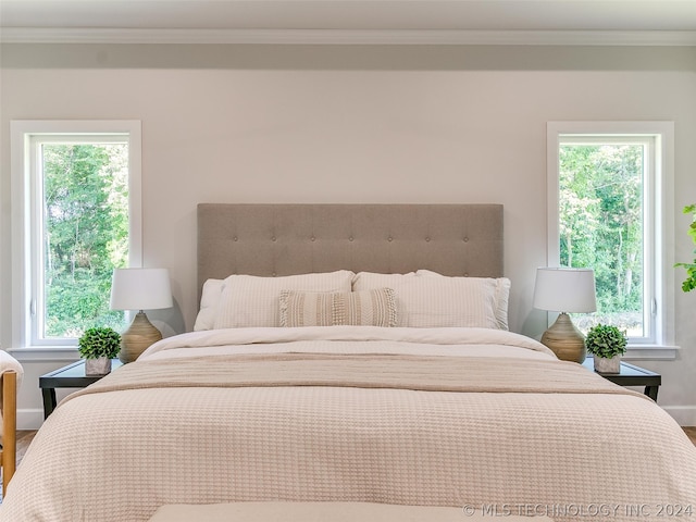 bedroom featuring multiple windows, crown molding, and hardwood / wood-style flooring