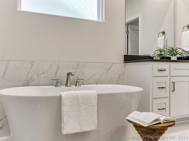 bathroom featuring oversized vanity and a tub