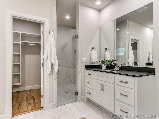 bathroom featuring an enclosed shower, tile flooring, and vanity