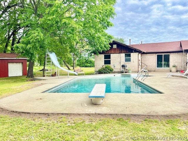 view of swimming pool featuring a patio, an outdoor structure, a diving board, and a water slide