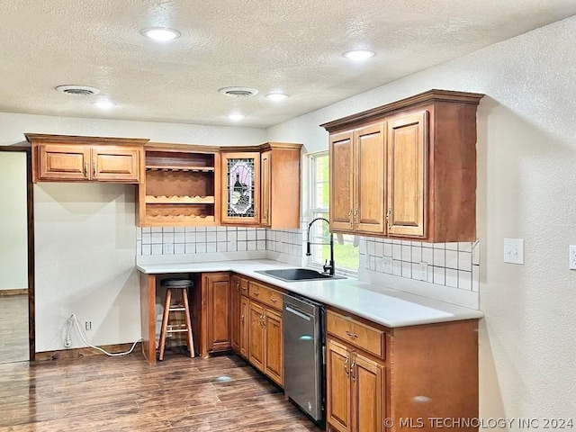 kitchen featuring sink, dishwasher, dark wood-type flooring, and decorative backsplash