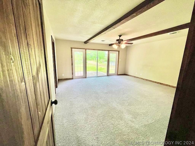 carpeted spare room featuring a textured ceiling, beam ceiling, and ceiling fan