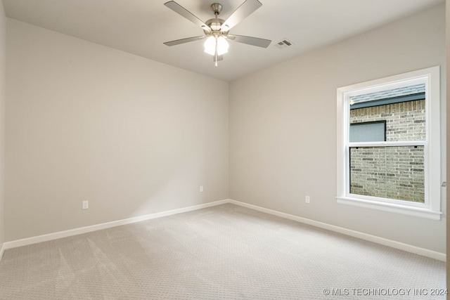 carpeted spare room with ceiling fan