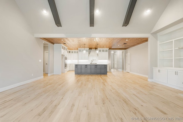 unfurnished living room featuring built in shelves, sink, wooden ceiling, light hardwood / wood-style flooring, and high vaulted ceiling