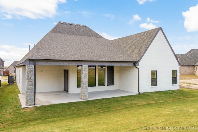 back of property with a lawn and a patio