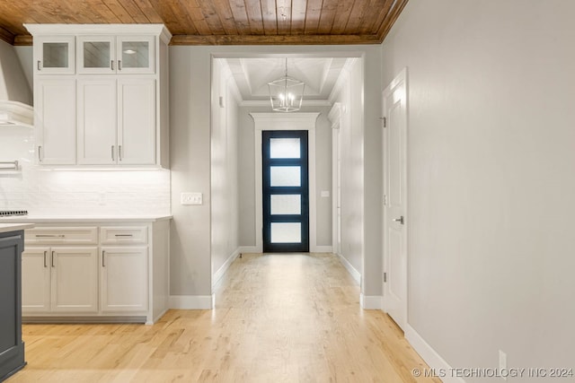 foyer featuring crown molding, wood ceiling, and light wood-type flooring