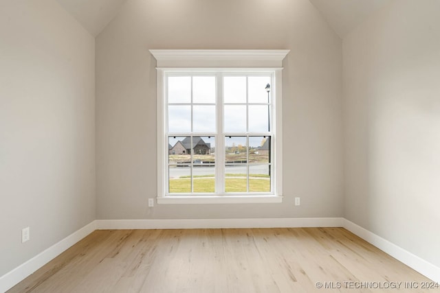 unfurnished room featuring light hardwood / wood-style floors and lofted ceiling