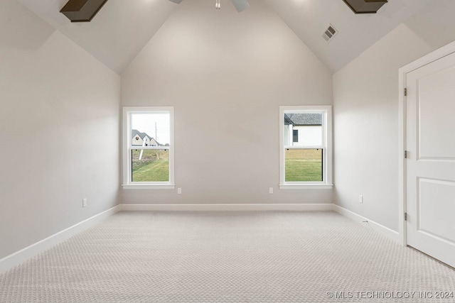 carpeted empty room featuring a wealth of natural light, high vaulted ceiling, and ceiling fan