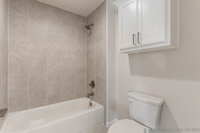 bathroom with tiled shower / bath and toilet