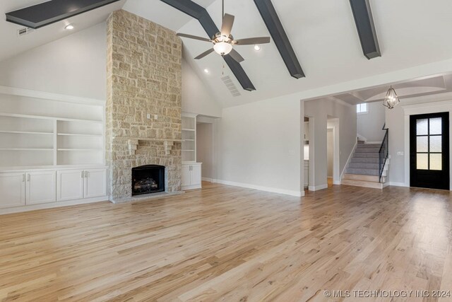 unfurnished living room featuring high vaulted ceiling, ceiling fan, a fireplace, and light hardwood / wood-style flooring