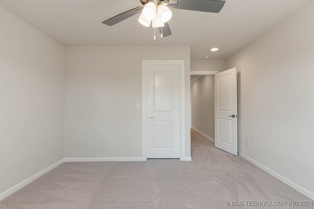 unfurnished bedroom with ceiling fan and light colored carpet