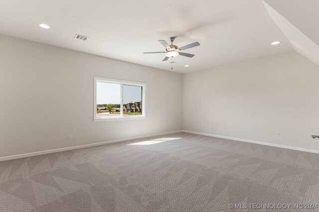 carpeted empty room with ceiling fan and vaulted ceiling