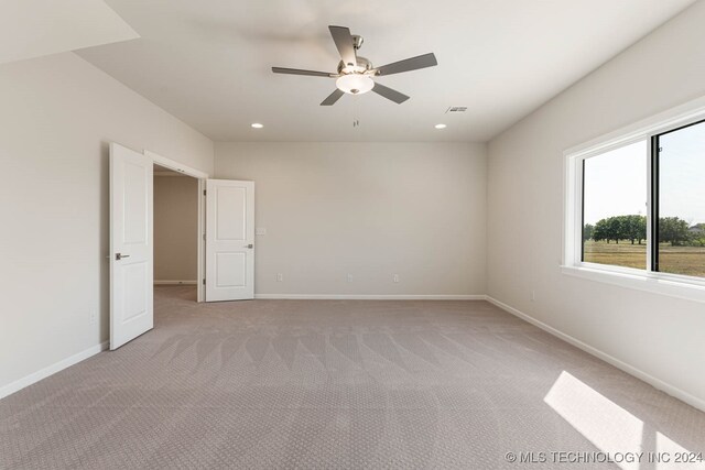 spare room featuring ceiling fan and light carpet