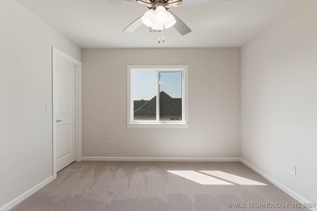 carpeted spare room with ceiling fan