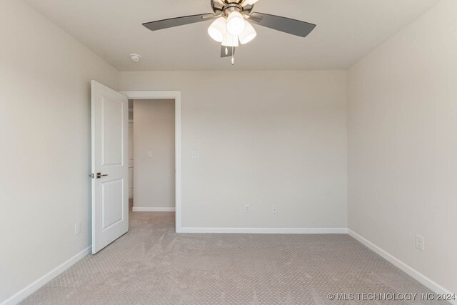 unfurnished room featuring light colored carpet and ceiling fan