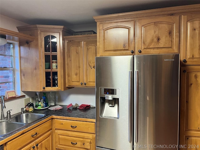 kitchen featuring sink and stainless steel refrigerator with ice dispenser