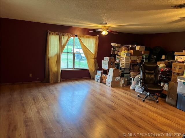 unfurnished office with hardwood / wood-style flooring, ceiling fan, and a textured ceiling