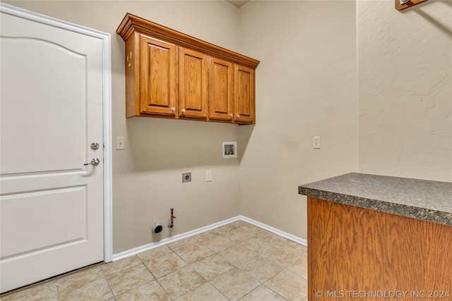 clothes washing area featuring electric dryer hookup, hookup for a washing machine, light tile floors, hookup for a gas dryer, and cabinets