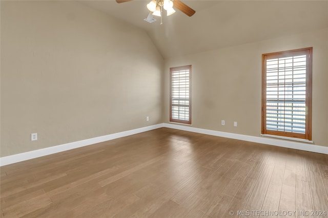 unfurnished room with hardwood / wood-style floors, vaulted ceiling, ceiling fan, and plenty of natural light