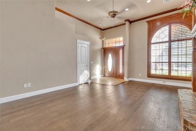 foyer with wood-type flooring and crown molding