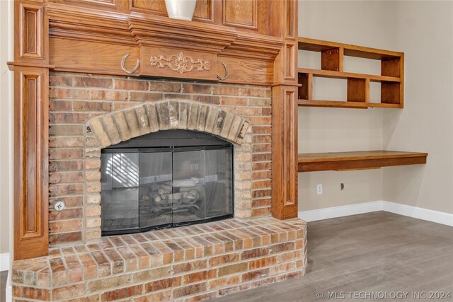 details featuring hardwood / wood-style flooring and a brick fireplace