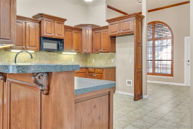 kitchen with backsplash, sink, and light tile floors