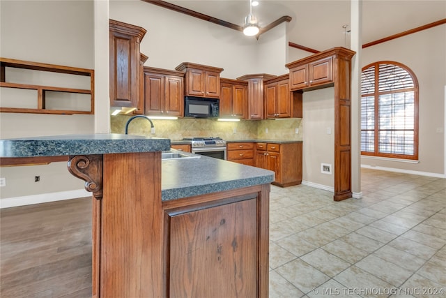 kitchen with kitchen peninsula, backsplash, stainless steel gas stove, light wood-type flooring, and ornamental molding