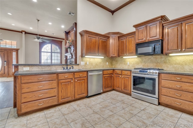 kitchen featuring kitchen peninsula, ceiling fan, stainless steel appliances, crown molding, and sink