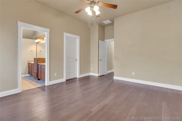 unfurnished bedroom featuring connected bathroom, wood-type flooring, and ceiling fan