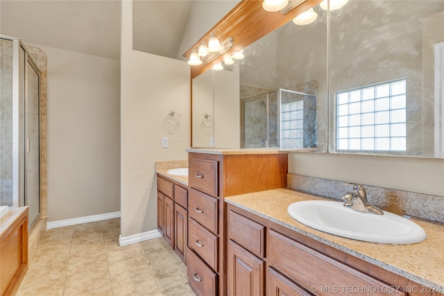 bathroom with walk in shower, vaulted ceiling, vanity, and tile floors