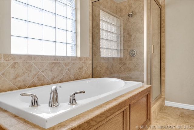 bathroom with a healthy amount of sunlight, tile floors, and separate shower and tub