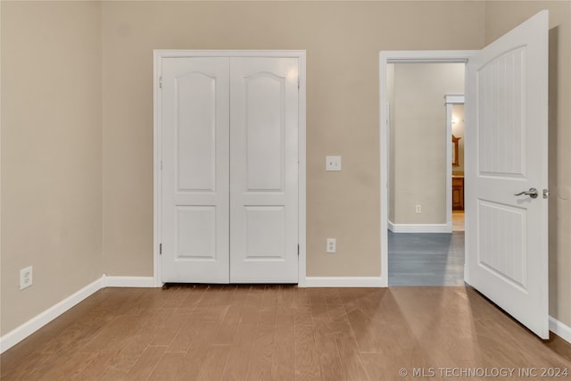 unfurnished bedroom with a closet and hardwood / wood-style floors