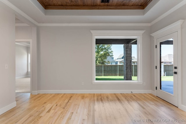 empty room featuring crown molding, a tray ceiling, light hardwood / wood-style flooring, and wood ceiling