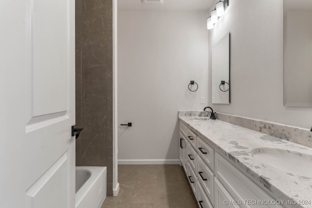 bathroom with vanity, a tub, and tile patterned flooring