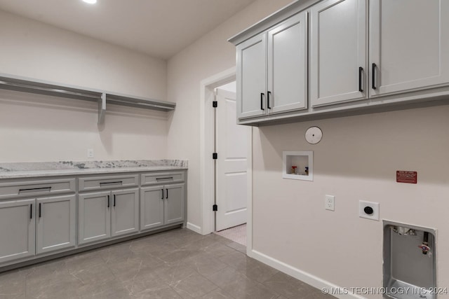 washroom with electric dryer hookup, washer hookup, and cabinets