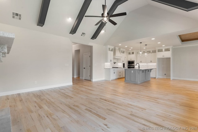 unfurnished living room with light hardwood / wood-style floors, beam ceiling, high vaulted ceiling, and ceiling fan