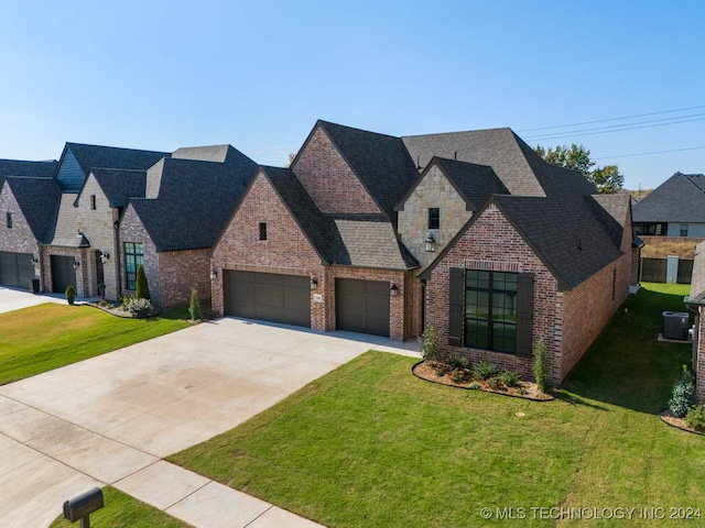 view of front of home featuring cooling unit, a garage, and a front lawn