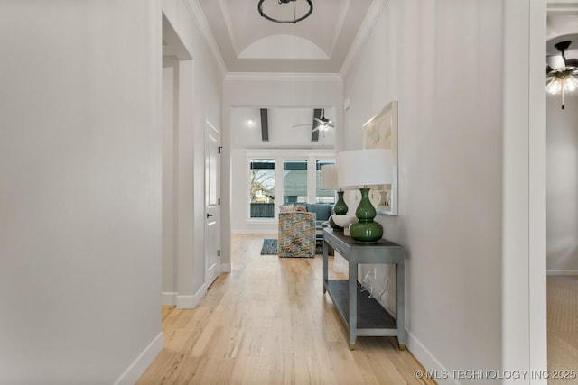 hall with ornamental molding, light wood finished floors, and baseboards