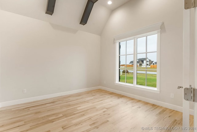 spare room featuring light hardwood / wood-style flooring and vaulted ceiling