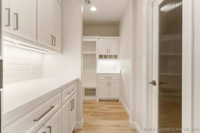 interior space with white cabinets and light wood-type flooring