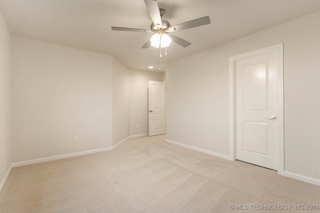 carpeted spare room featuring ceiling fan