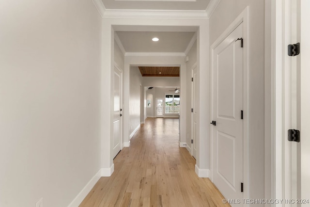 hallway with ornamental molding and light hardwood / wood-style floors