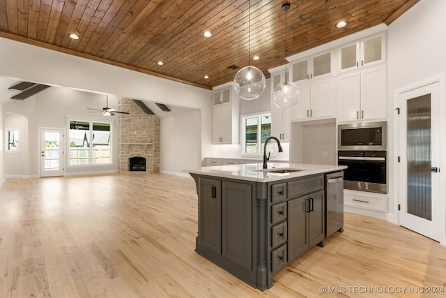 kitchen with an island with sink, white cabinetry, appliances with stainless steel finishes, and a healthy amount of sunlight