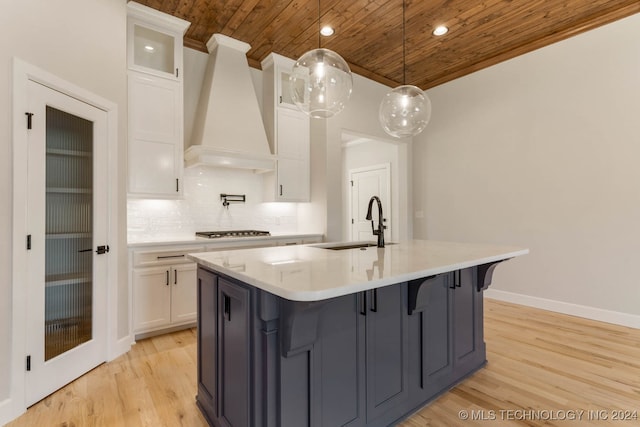 kitchen featuring white cabinets, custom exhaust hood, and light hardwood / wood-style floors