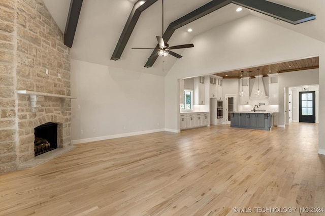 unfurnished living room featuring high vaulted ceiling, ceiling fan, and plenty of natural light