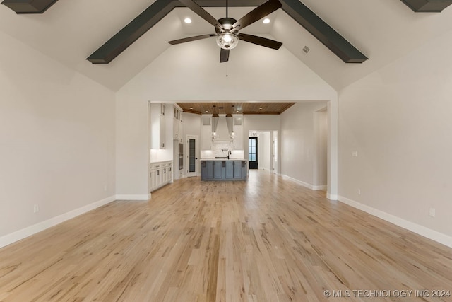 unfurnished living room featuring ceiling fan, sink, beam ceiling, light hardwood / wood-style flooring, and high vaulted ceiling